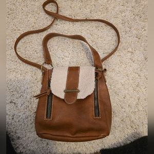 Small faux leather satchel bag with adjustable crossbody strap and hand strap.